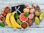 Foods containing natural potassium. K: Potatoes, mushrooms, banana, tomatoes, nuts, beans, broccoli, avocados. Top view. On a white wooden background.